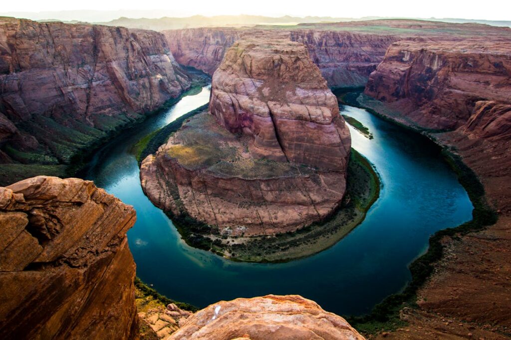 Horseshoe Bend in Arizona, showcasing the breathtaking curve of the Colorado River surrounded by towering red rock formations at sunset.