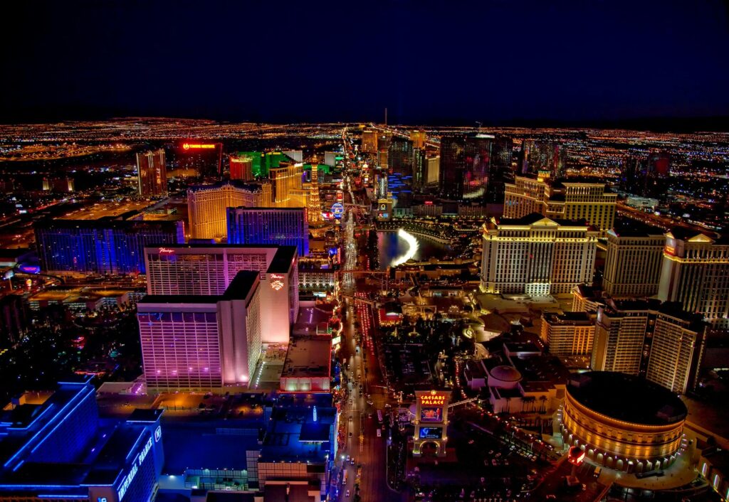 A stunning aerial view of the Las Vegas Strip at night, showcasing the city's bright neon lights, famous hotels, and bustling streets.