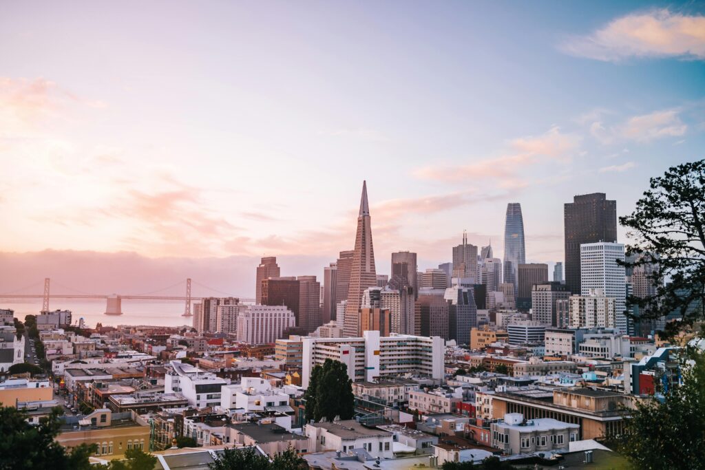 San Francisco skyline at sunset, with the Transamerica Pyramid and Bay Bridge in view.